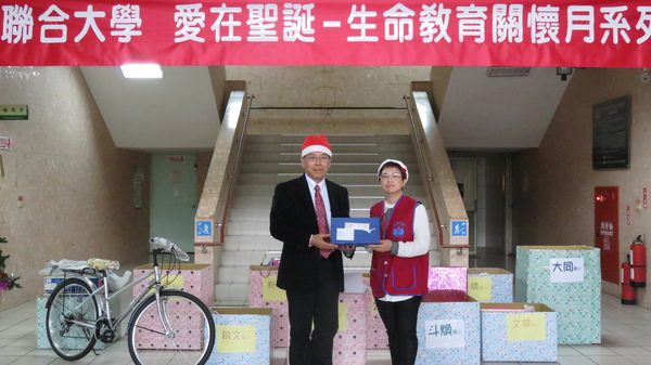 聯大校長蔡東湖(左)贈送募集聖誕禮物給生命之愛文教基金會執行長蘇雯娟
