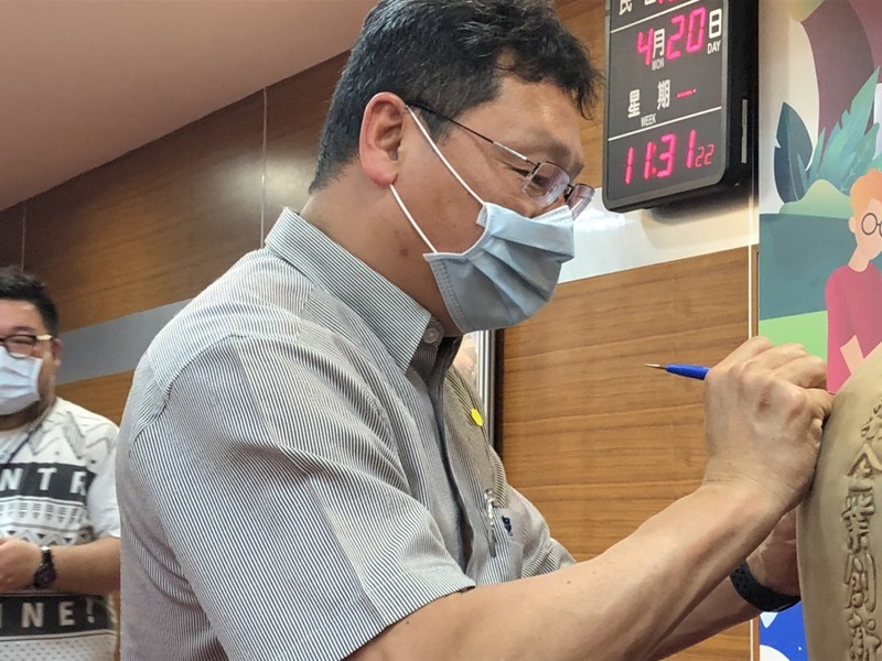 副校長張良漢在「聚寶甕」土坯上簽名落款，作為聯盟簽署見證圖片