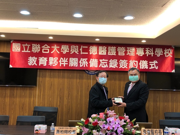 聯大李偉賢校長(右)接受仁德醫專黃柏翔校長致贈紀念品