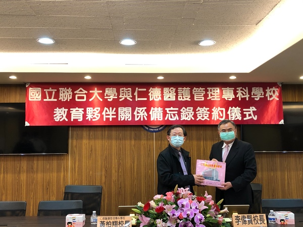 聯大李偉賢校長(右)接受仁德醫專黃柏翔校長禮品