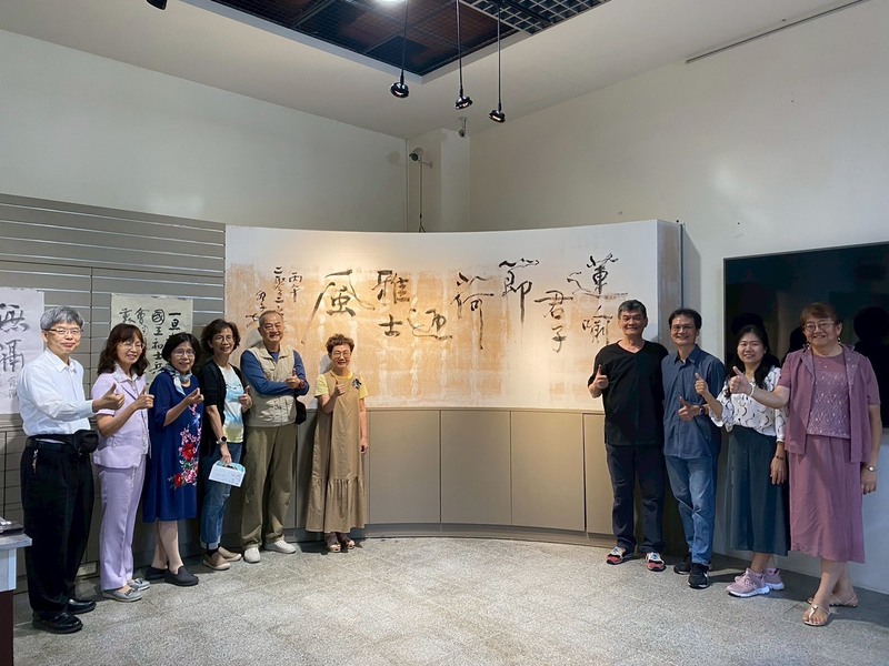 圖1.吳季如老師為聯大現場揮毫書藝作品「蓮喻君子節、荷迎雅士風」後與聯大師長合影留念圖片