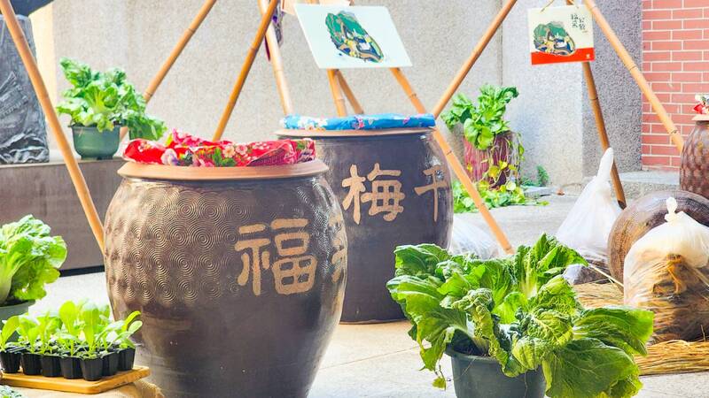 圖4.竹架上懸曬的芥菜與滿裝福菜、梅干菜的陶甕，生動重現客庄順應時序的醃漬智慧。圖片