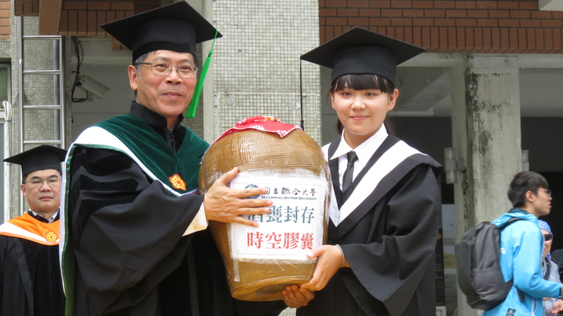 畢業生將封好的甕交給聯大校長蔡東湖(左)
